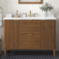 a bathroom vanity with two sinks and a mirror above it, in front of a white tiled wall