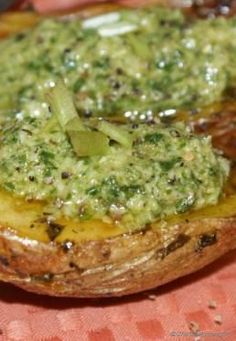 two pieces of bread with green toppings on them sitting on top of a table