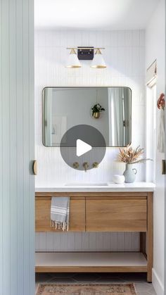 a bathroom with a sink, mirror and rug