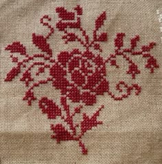 a cross stitch pattern with red flowers on it