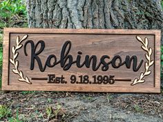 a wooden sign that says robinson with an oak tree in the background