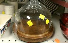 a cluttered kitchen counter with yellow sticky notes stuck to the glass dome on top