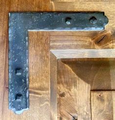 a close up of a door handle on a wooden floor with nails and screws