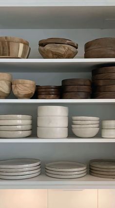 the shelves are filled with plates and bowls