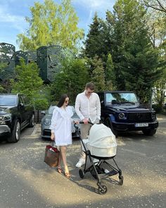 a man and woman pushing a baby in a stroller