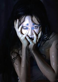 a woman covered in water holding her hands to her face