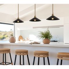 three stools in front of a kitchen island with potted plants on it and an open window