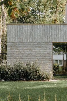 a brick building sitting next to a lush green field