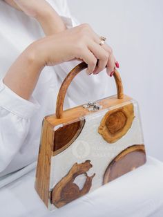 Nusantara Cari Handmade Wooden Teakwood Handbag, Top Handle Bag with Epoxy Resin, Women Fashion Handbag, Women Gift Materials: Teak Wood, Epoxy Resin, Premium Gail for Inner 📐Dimensions: Length: 24 cm / 9.4" Width: 6.5 cm / 2.6" Height: 25 cm / 9.8" 👜 Unique Design: One pattern for each handbag. The item received will have a different pattern from the picture since it's a natural wood. ✨ These wooden bags are made by hand, which means more attention to detail and higher quality items.  ✨ Eco-f Wood Bags Handmade, Gift Bamboo Handle Handheld Shoulder Bag, Gift Handheld Shoulder Bag With Bamboo Handle, Handheld Shoulder Bag With Bamboo Handle As Gift, Rectangular Bags With Wooden Handle For Everyday Use, Rectangular Natural Satchel As Gift, Brown Box Bag With Detachable Handle As Gift, Natural Color Bags With Detachable Handle For Gift, Brown Box Bag With Detachable Handle For Gift