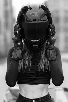 a woman wearing a helmet and holding her hands to her face