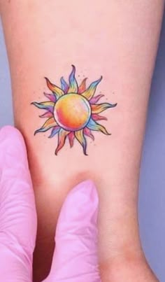 a woman's foot with a small sun tattoo on the side of her leg