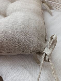 a close up of a pillow on a bed with white sheets and pillows in the background