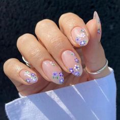 a woman's hand with pink and purple nail polish