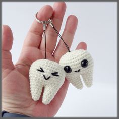 two crocheted teeth are being held in the palm of someone's hand