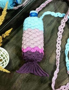 a crocheted water bottle cover with a tassel