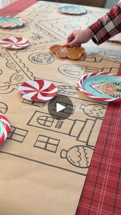 a table with paper plates on it and candy canes scattered around the placemats