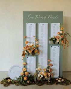 an arrangement of flowers and greenery is displayed in front of a sign that reads out first place