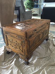 a wooden box sitting on top of a white sheet covered floor next to a chair