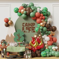 an assortment of balloons and decorations are displayed on a table with a sign that reads camp life