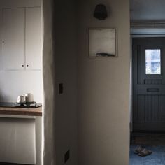 a kitchen with white cabinets and black door