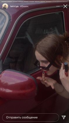 a woman sitting in the driver's seat of a car talking on her cell phone