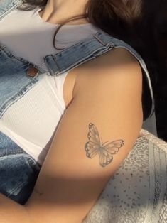 a woman with a butterfly tattoo on her arm