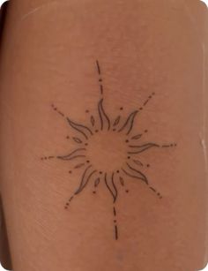 a small sun tattoo on the back of a woman's leg