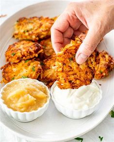 a person dipping something into some kind of sauce on a plate with other food items