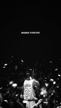 a basketball player standing in front of a crowd with his jersey on and the words mamba forever above him