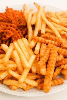 french fries on a white plate with other food items