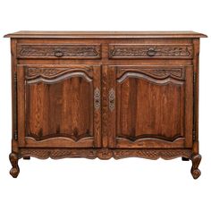 an old fashioned wooden cabinet with carvings on the front and side doors, in dark wood