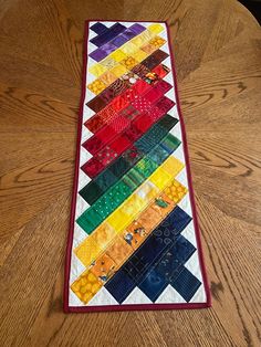 a quilted table runner on top of a wooden table