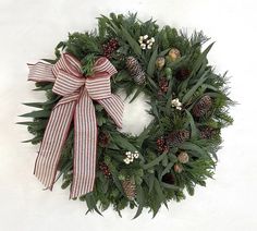 a christmas wreath with pine cones and berries