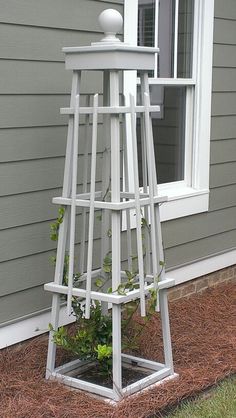 a white wooden plant stand in front of a house