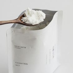 a wooden spoon filled with white powder on top of a bag