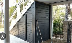 an open door leading to a house with a stair case on the outside and a window in the inside