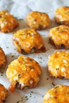 mini cheese burgers with melted cheese and herbs on the top are ready to be eaten