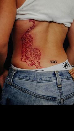 a woman with a tiger tattoo on her stomach and the word ti in red ink