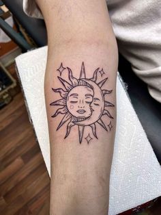 a sun and moon tattoo on the arm