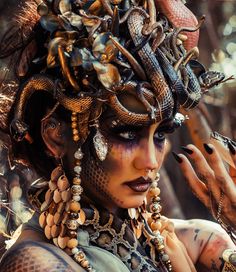 a woman with lots of jewelry on her face and hands, wearing an elaborate headdress