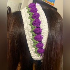 a woman wearing a white and purple crochet headband