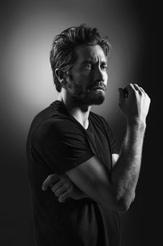 black and white photograph of a man with his arms crossed looking up to the side