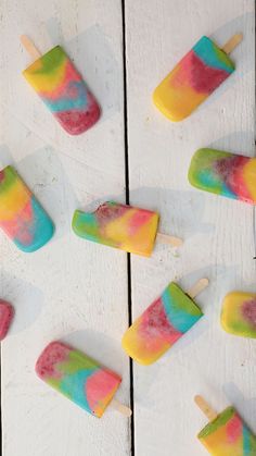 colorful popsicles are arranged on a white table