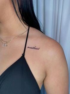 the back of a woman's neck with her name tattooed on it