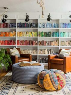 a living room filled with lots of furniture and bookshelves covered in colorful books