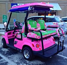 a pink and green golf cart parked in front of a building