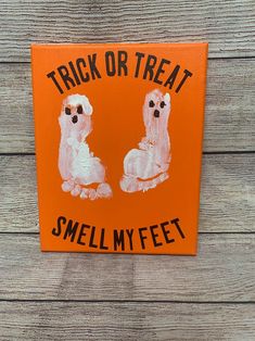 an orange sign that says trick or treat smell my feet with two poodles painted on it