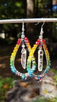 "These HOOPS are the perfect way to jazz up any casual or formal outfit. Bold RAINBOW colors are screaming vibes of fun! These HOOPS are eye catching with the movement in the center with clear QUARTZ crystal POINT that \" swinging\" in the middle of the hoop.  These have such a Bo-Ho vibe they're sassy edge would flow with any outfit!   I wire wrapped the hoops using an assort of rainbow colored glass beads that surround the hoop! The color combo is stunning....PaPOW!!     This is a one-of-a-kind item and you can feel extra special knowing you are the only one who owns this particular piece or confident you are giving a very special gift. A wonderful way to support PRIDE with gorgeous rainbow of colors surrounding the teardrop hoop and a clear quartz point dancing in the middle. CLEAR QUAR Fun Rainbow Jewelry For Festivals, Handmade Rainbow Teardrop Jewelry, Handmade Angels, Mermaid Earrings, Hippy Gifts, Nature Earrings, Rainbow Quartz, Clear Quartz Point, Pride Rainbow