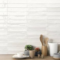 kitchen utensils and coffee cups on a wooden table with white tiles in the background