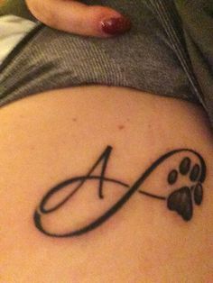 a woman with a tattoo on her stomach that has an animal paw and the letter a in it